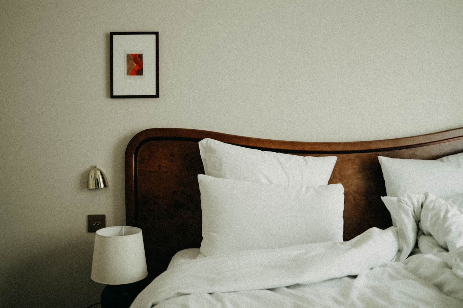 A calm, well-appointed hotel bedroom with warm wood tones