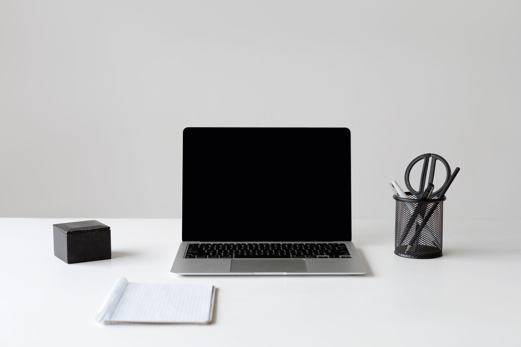 A clean, minimal desk with an open laptop