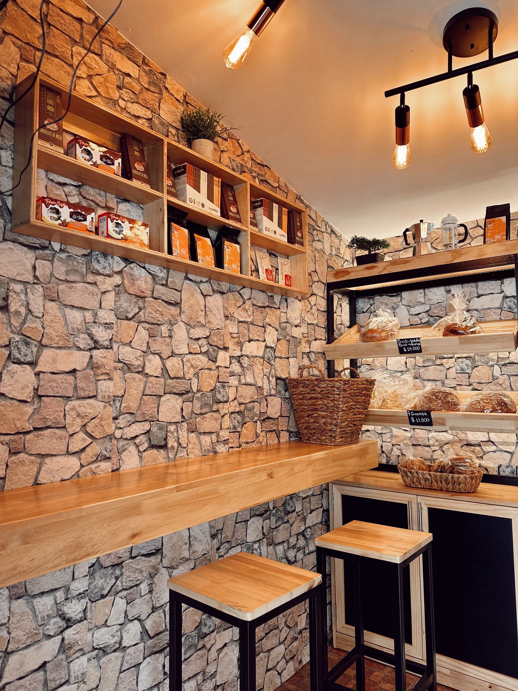 A warm, stone-walled independent bakery and shop interior