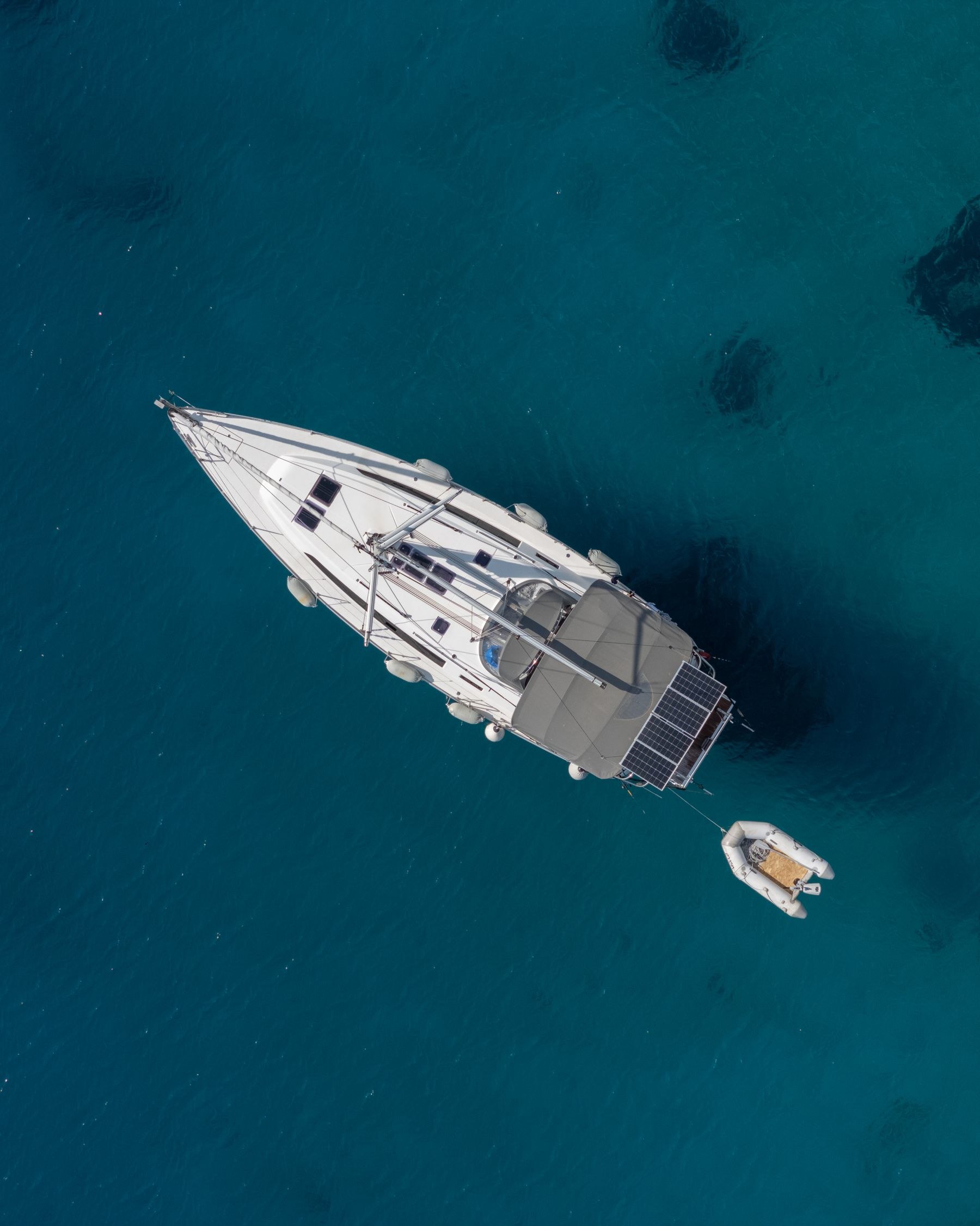 A luxury yacht in clear blue water, aerial view